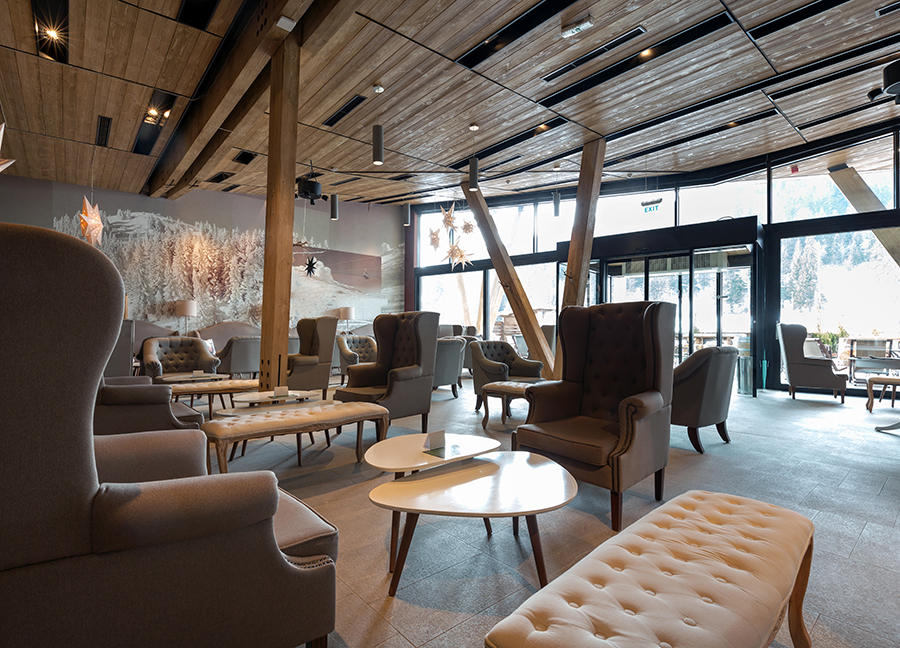 Lobby of boutique hotel featuring chic armchairs and lounges.